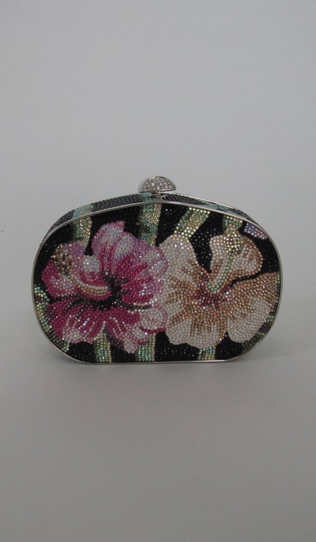 Judith Leiber crystal Jewel minaudiere,orchid design with silver trim and chain,lined in silver...with change purse, mirror & comb, protector bag and original box...In excellent condition, looks barely if ever used.

Measurements are:  
5 1/4