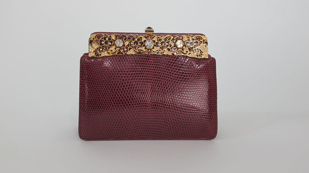 Judith Leiber Burgundy lizard clutch with enamel & jewel frame...Can be used as a clutch or there is a hidden,narrow gold chain strap inside...With original mirror & comb, change purse & protector bag with original box...In excellent barely used