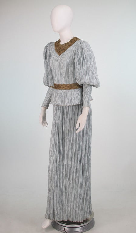 Mary McFadden Fortuny style pleated gown with gold macrame yoke and waist band...In the colour of the winter sky, silvery, blue gray...Renaissance style gown with yoke and waist of gold macrame, gigot sleeve, peplum waist, fluid skirt...In excellent