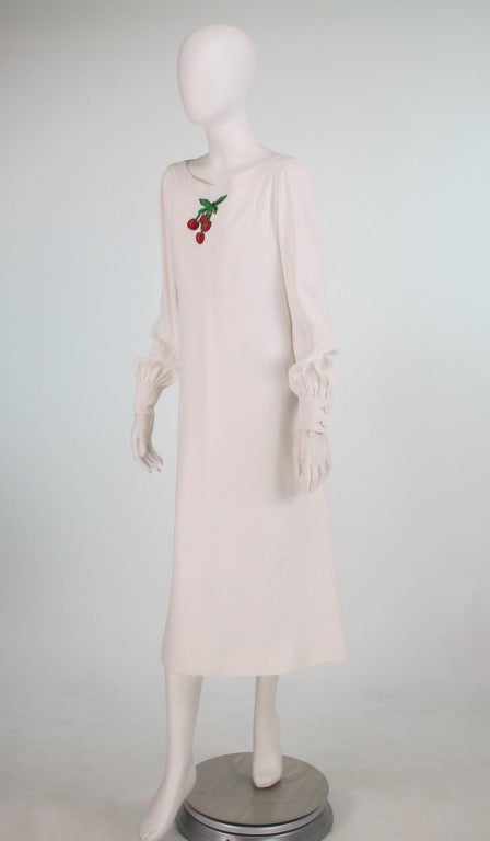 Ivory white crepe midi dress with an embroidered applique of 3 red cherries...From the early 1970s...Banded bateau neckline with narrow pin tucks at the bodice front, long full sleeves are gathered into wide cuffs with double button closure...A line