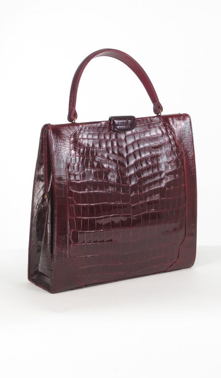 Large & fabulous, a bag to envy!!!! Burgundy glazed crocodile handbag from Lucille de Paris...Frame style bag from the 1950s, with unusual clasp that lifts up and down...From the estate of 1950s model Betsy Kaiser...The bag is in excellent