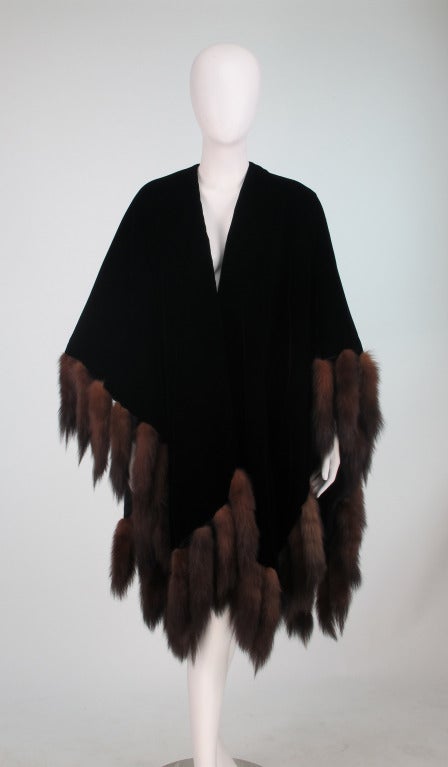 Luxurious & over the top, black velvet cape...Trimmed with lush sable tails and lined in warm fuzzy jersey...From Adrienne Landau circa 1980s,( the label was removed because the cape is reversible)...In excellent wearable condition...Fits most