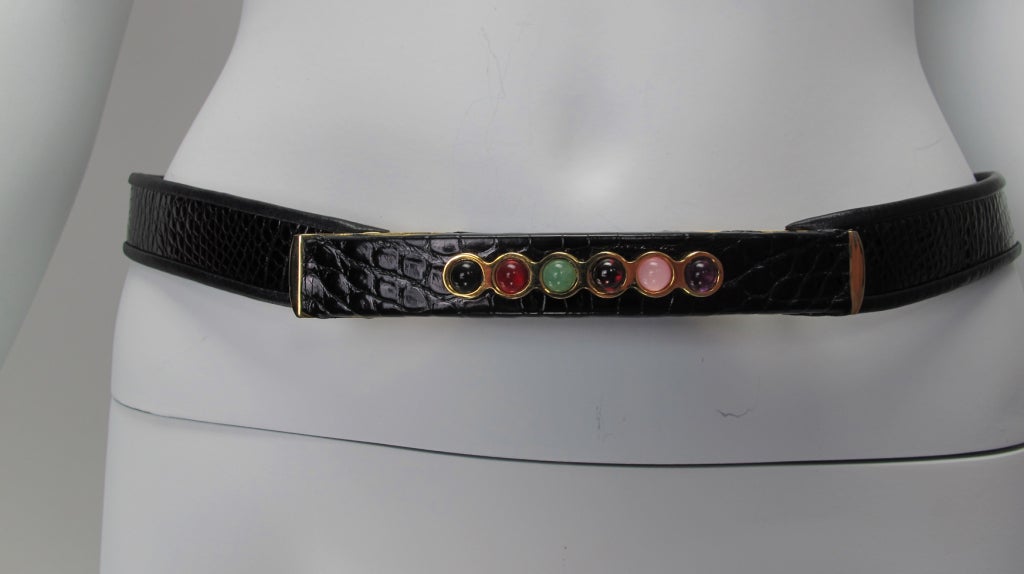 Narrow glazed black alligator belt, finely finished with an architectural influenced decorative “buckle”…three dimensional raised center tapers at each end and is set with gold bezel semi precious quartz cabochons…gold hardware…closes with a hidden