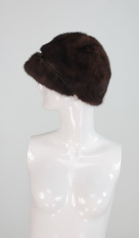 From the 1960s this mink visor hat has a very Mod feel...Sold at Saks Fifth Ave, it is in excellent wearable condition...Peaked cap with narrow silk band and ribbon bow at the front...Chestnut brown mink has it's original glaze...

Measurements