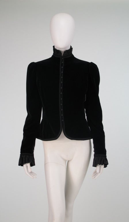 Yves St Laurent 1970s black velvet poet style jacket...Romantic jacket with high ruffle collar and cuffs of taffeta, working button & loops at cuffs, closes at the front with buttons and loops, edged in corded satin...jacket is fully lined...Marked