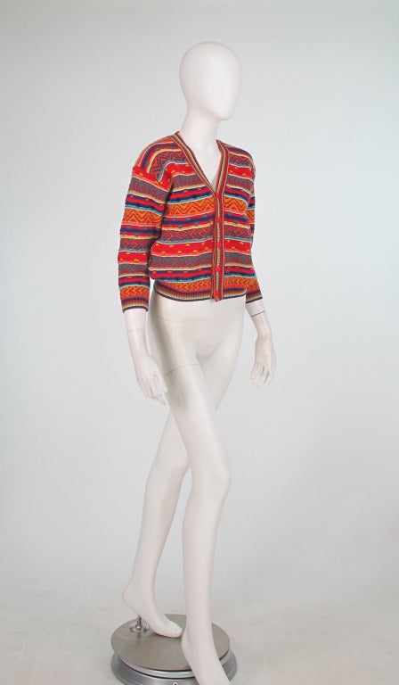 An early sweater from Missoni in a folkloric pattern of bold colours...The early 1960s was the time the Missoni's developed the patterns that have made them famous...Cropped cardigan sweater that closes at the front with red logo buttons...3/4