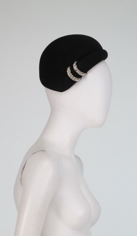 From the 1960s a black wool cocktail hat with rhinestone trim...side rolled brim...fabric is marked Halson...Labeled Halston....

Measurements are:
21 1/4