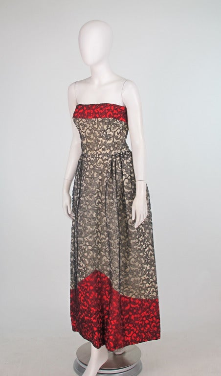 Custom made, from Bergdorf Goodman and dated 1963...Spidery black silk Madeira lace over ivory silk taffetta and red silk satin evening gown...The classic strapless bodice has a band of red silk satin at the top and ivory silk taffeta to the waist,