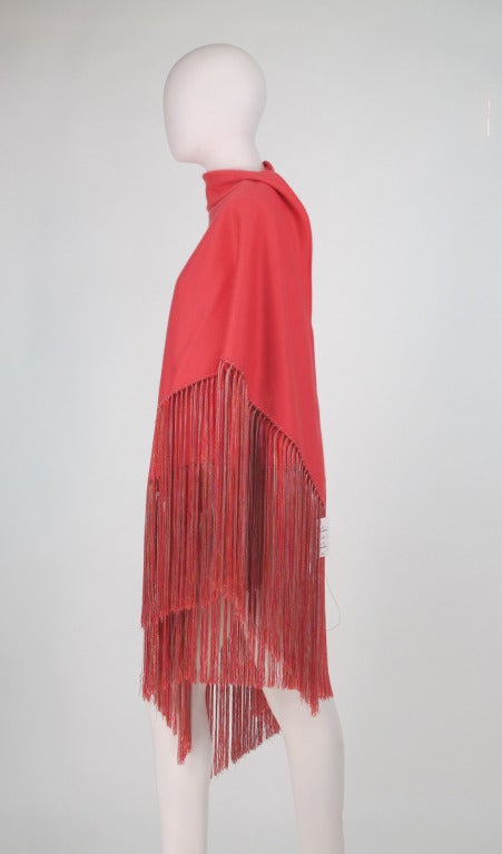 Luxurious 100% cashmere shawl in coral/shrimp from Colombo, made in Italy,  one of the most renowned weavers of cashmere fabrics anywhere in the world:...The large triangle shape shawl is trimmed on three sides with long shimmering hand knotted silk