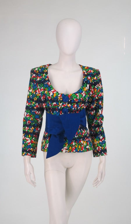 Vibrant 1980s Yves St Laurent YSL floral jacket with wrap belt...Bright floral print jacket has a deep scoop neck line...Closes at the front with large blue buttons that match the faille wrap belt...Jacket is fully lined...Wrap belt is