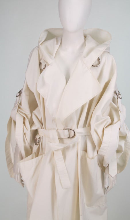 1980s Jean-Charles de Castelbajac hooded white cotton poplin big coat...This coat has a large collar that snaps together to form a hood...The long full sleeves can be gathered up via tabs & D rings on the sleeves...The coat comes with a self belt