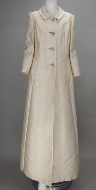 Cream silk shantung blend evening coat...labeled Lord & Taylor from the 1960s...princess seamed...on seam front pockets...round collar...bound buttonholes with jeweled buttons...fully lined...looks barely worn...

All our clothing is dry cleaned