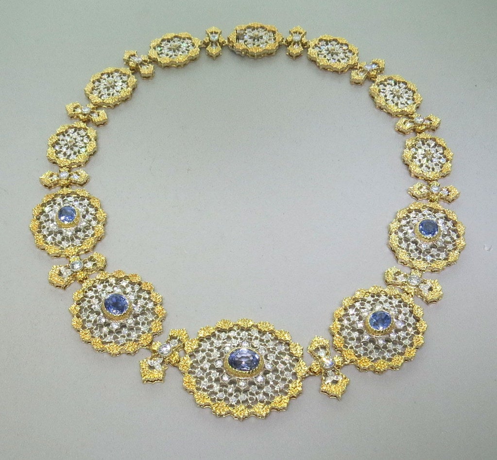 Gold and silver necklace composed of 12 oval openwork elements set with 5.73ctw in diamonds and 9.97ctw in sapphires. 16 3/4