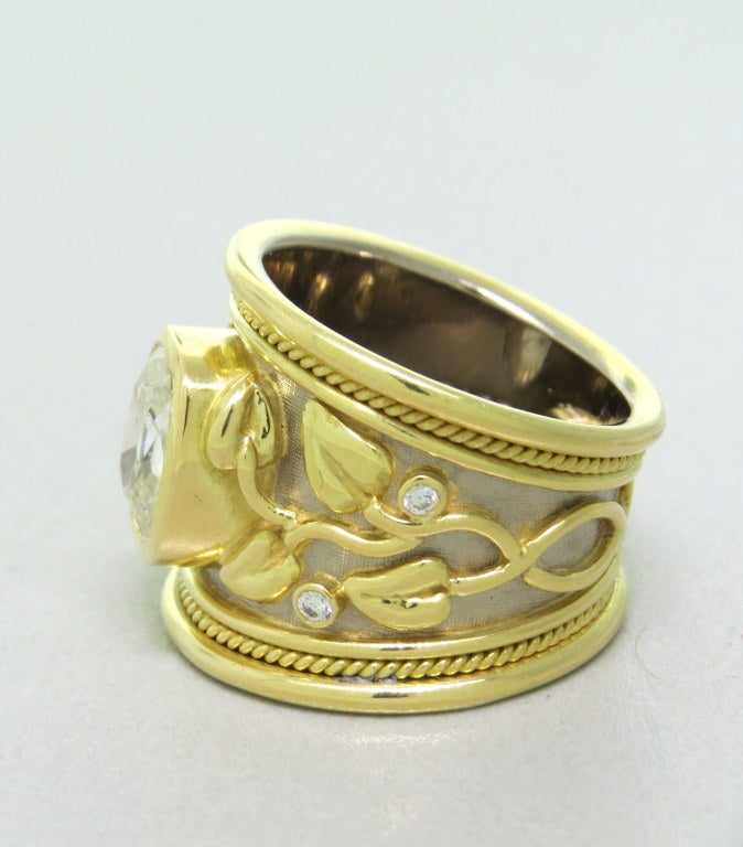 Tapered Templar Ring Old cut, cushion shaped diamond approx. 1.75ct with carved gold myrtle leaves and diamonds .Ring is a size 5 1/2 and is 18.3mm wide at widest point.
