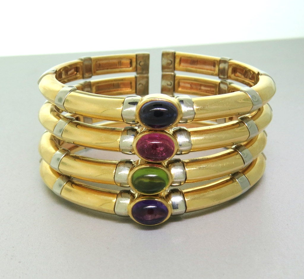 18k Yellow & White Gold, Gem stones -iolite, pink tourmaline, peridot, amethyst. 32mm wide . flexible open cuff construction. 
weight: 136.5g !!! Cuff will fit up to 6 1/2