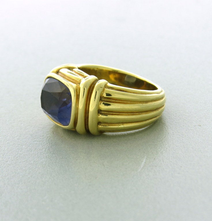 18k yellow gold, cushion cut Iolite 10.8mm X 8.5mm. Top of the ring 11.1mm at the widest point. Ring is a size 4 1/4.