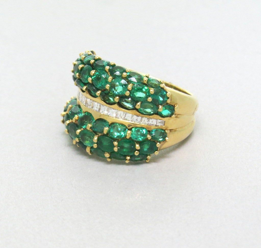 18k yellow gold, approximately 5.00 -5.50ctw emerald green top quality emeralds and approximately 0.80ctw square cut diamonds VS/F. The ring is 16mm wide. Finger size 6 3/4. 
weight 12.4g.