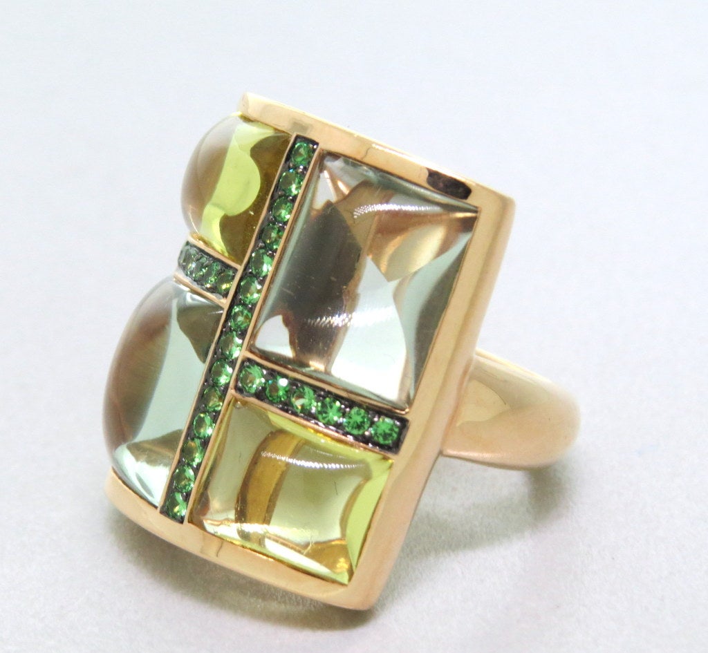 18k Gold Ring set with cabochon cut  citrines and topaz, accented with channel set green garnets. Top ring 23mm X 19mm, Ring size 6 1/4. Weight: 15g.
Marked: 750, FSR.