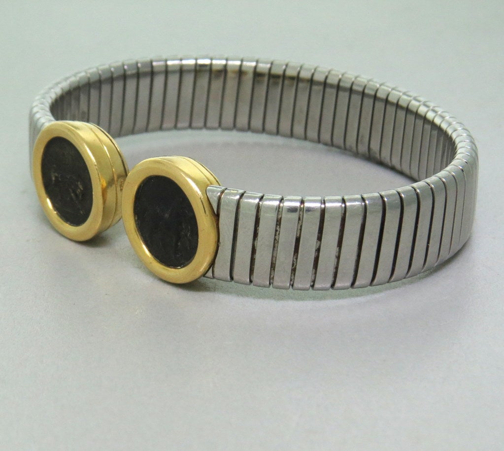 18k gold, steel , ancient coins , open cuff bracelet. 12mm wide , coin set in bezels 15mm in diameter. will fit up to 7 1/2