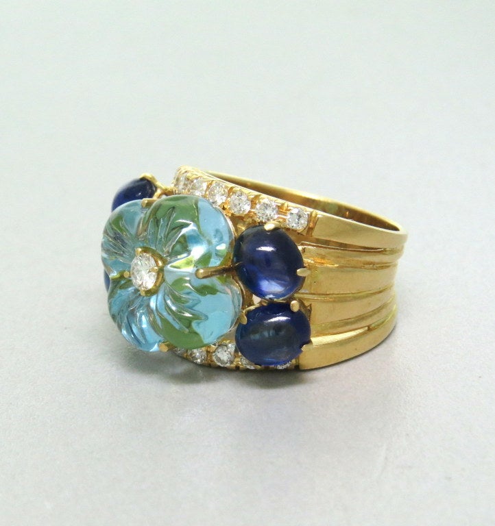 Beautiful 18k yellow gold ring with carved light blue topaz flower,2.20 - 2.40ctw sapphire cabochons and approx. 0.55ctw diamonds. Ring size 8, ring top is 17mm at widest point. weight - 15.7g