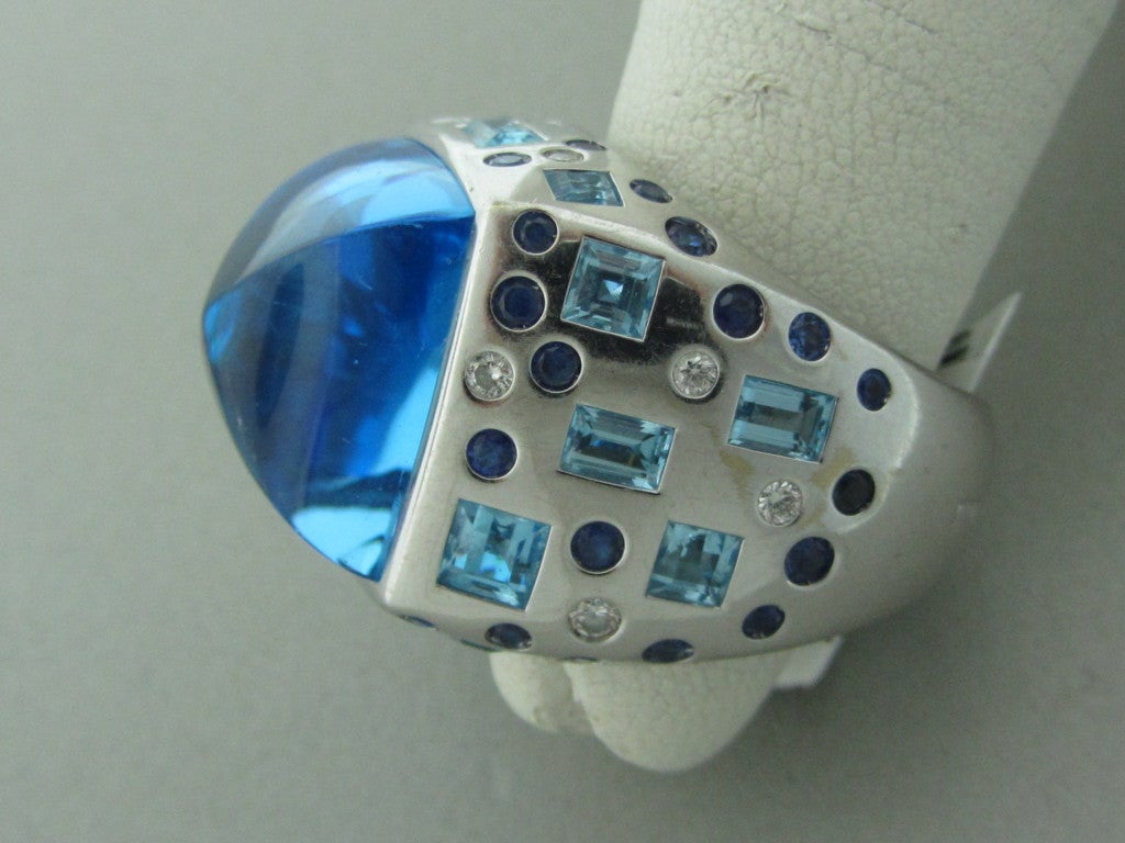18K White Gold Marked: Rayner,750,R,RHR. Gemstones/Diamonds: Blue Topaz - 15.5mm X 15.5mm Sapphires Diamonds - Approx. 0.24ctw Clarity: VS Color: G Measurements: Ring Size - 6 1/2, Ring Is 20mm Wide (Inch = 25mm) Weight: 27.8g