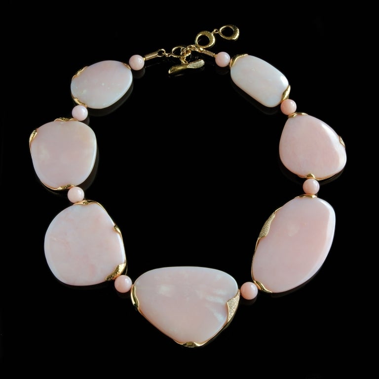 A statement necklace of Peruvian opal in flat, free-form shapes edged with 18K gold and interspersed with Peruvian opal beads. Pave diamonds highlight the gold edging and fastener in places, and the fastening allows the necklace to be worn at three