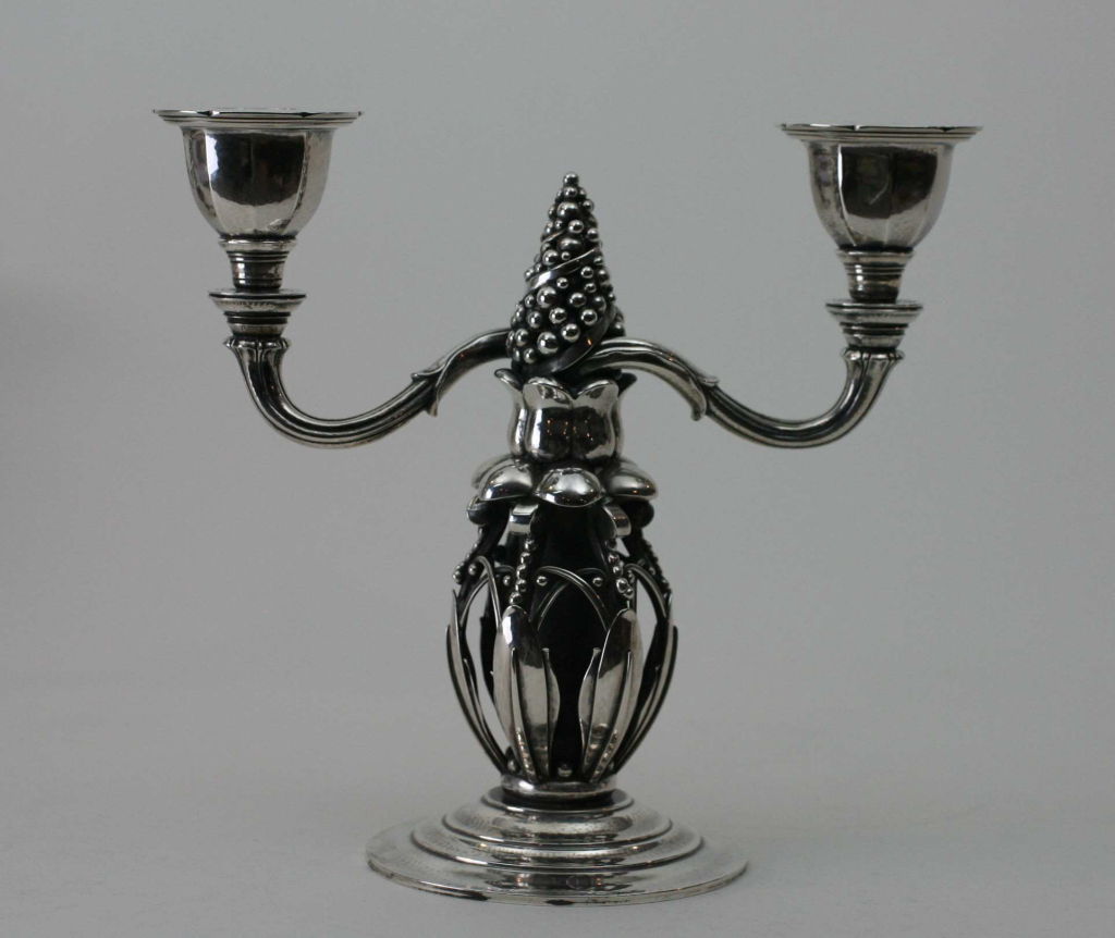 Pair of Georg Jensen sterling silver candelabra, no. 244, featuring an Art Deco 'Pine Cone' motif. Designed by Georg Jensen in 1918 and approximately 8.25 inches tall. Each candlelabra has impressed company marks for Georg Jensen, Denmark, Sterling,
