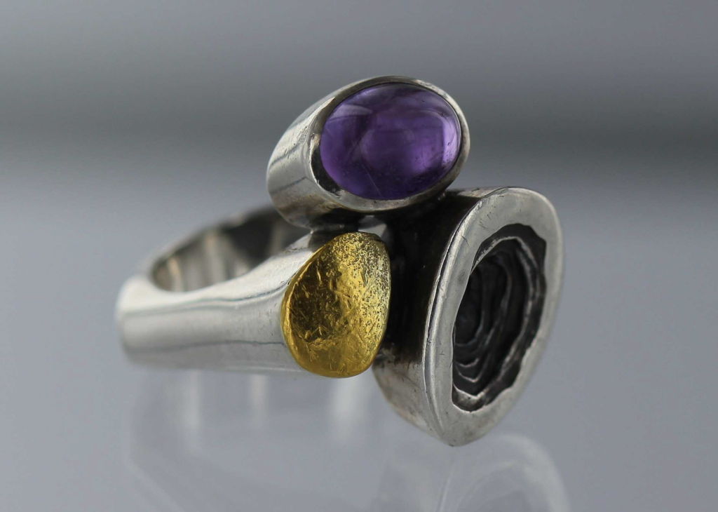 Danish modern ring designed by Jan Lohmann.  Sterling silver with cabachon amethyst and yellow gold.  The ring is size 10 and can be resized at no additional charge.  The ring bears impressed marks and is in excellent condition.