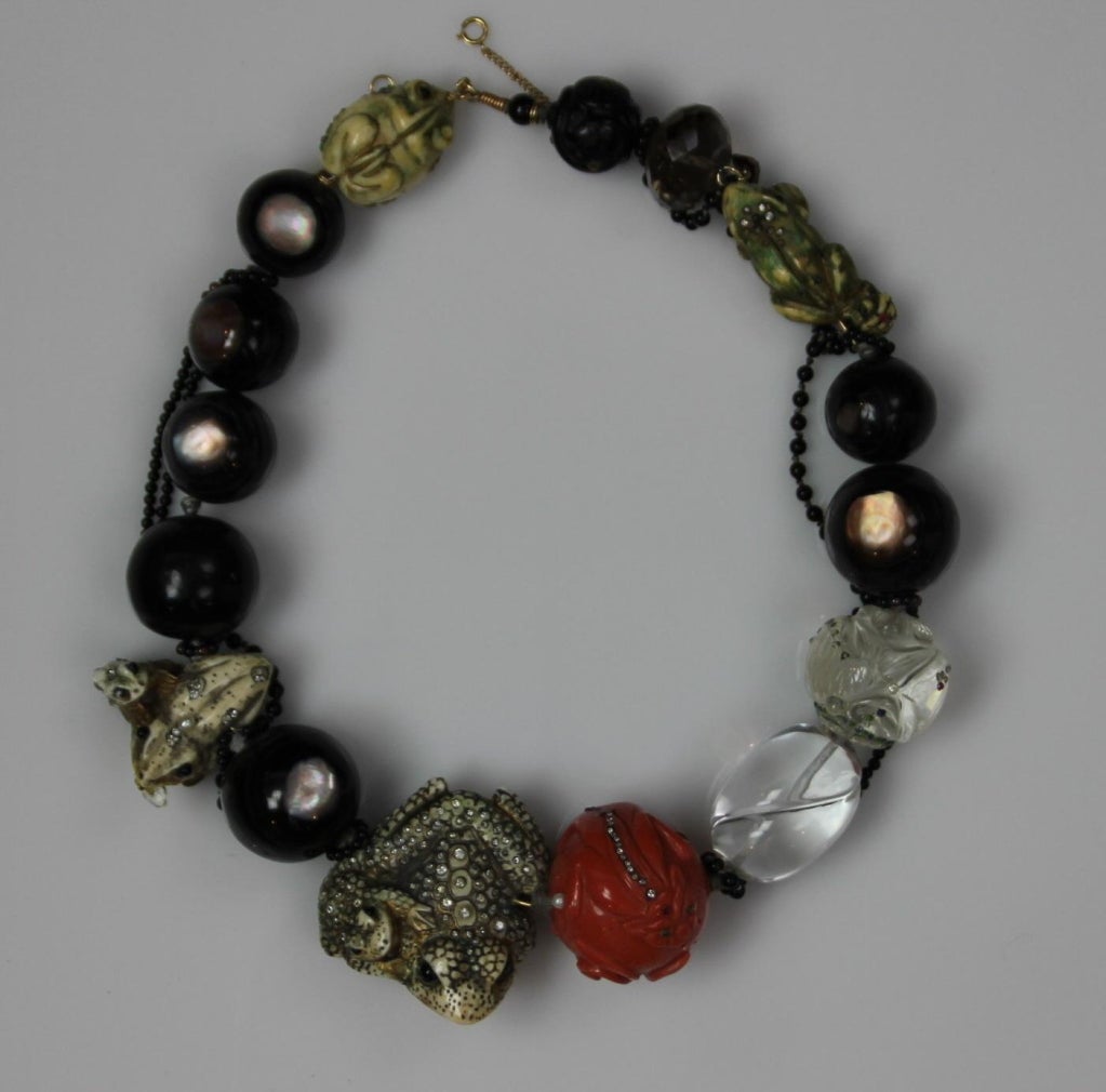 CONSTANCE ABERNATHY Carved Hardstone and Bone Netsuke Necklace in frog motif. This necklace features:Carved bone, coral, tiger eye, rock crystaland smokey quartz beads decorated with diamonds, rubies, emeralds, sapphires, garnet, pearl,and