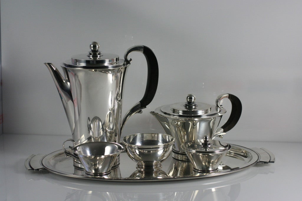 GEORG JENSEN Pyramid Coffee & Tea Service No. 600.  This is a five-piece coffee and tea service consisting of the following individual pieces: Oval tray, Coffee Pot, Tea Pot, Covered Sugar and Creamer.  This service was designed by Harald Neilsen in