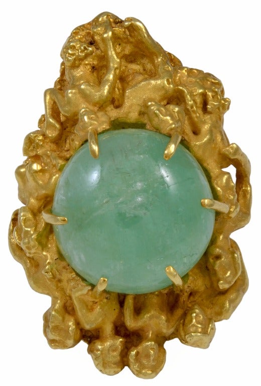 ERIC DE KOLB Gold and Emerald Ring.  This gold sculptural ring of overlaying bodies is topped with cabachon emerald (approximately 3/4