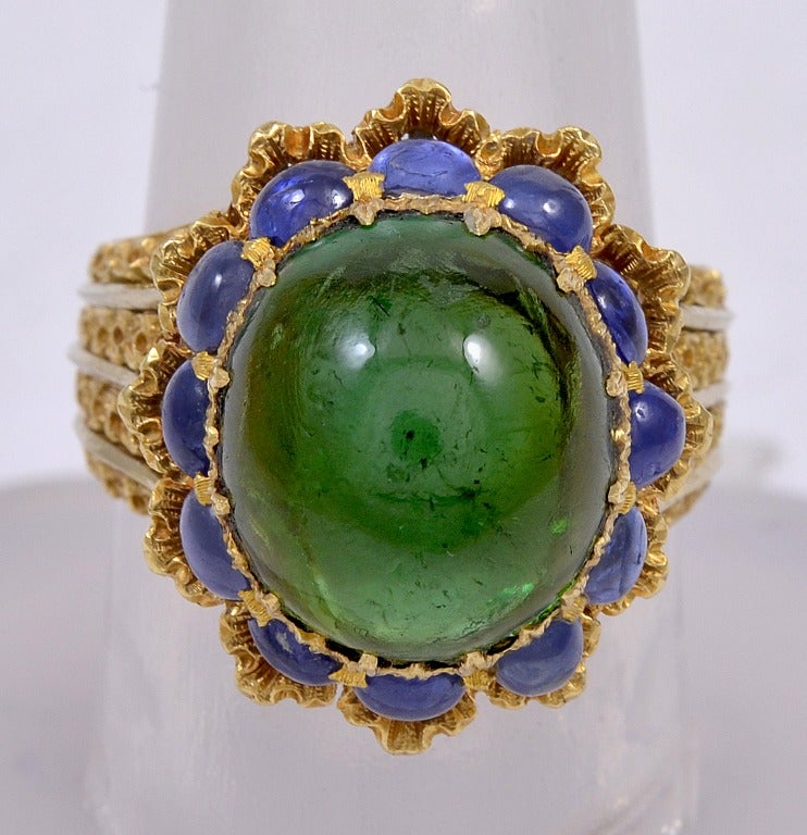 BUCCELLATI Gold, Natural Tourmaline and Sapphire Ring; 18kt gold ring composed of engraved leaf garlands crowned by central cabachon emerald set over fourteen round cabachon sapphires framed by pierced gold ribbon.  tourmaline approximately 7-8