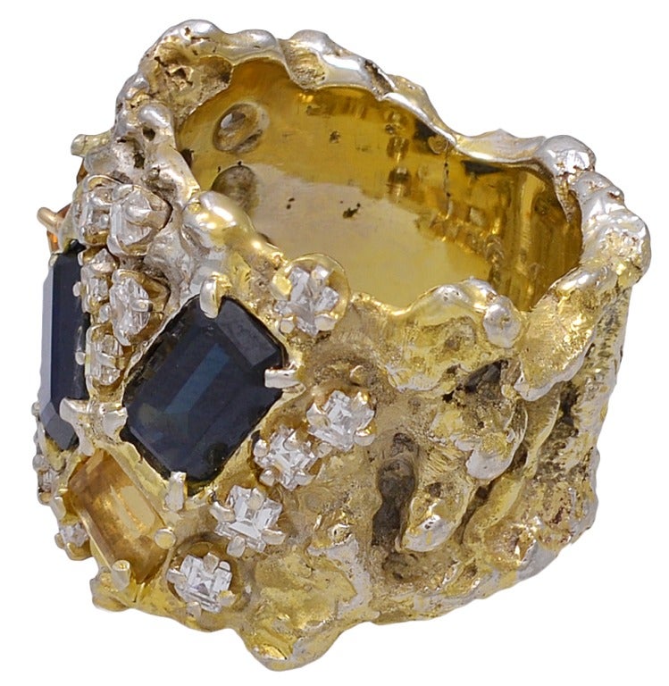 Gold, Diamond, Sapphire and Beryl Ring by Arthur King.  The ring in 18 karat yellow and white gold set with baguette yellow beryl and sapphires and surrounded by round brilliant and fancy-cut diamonds.  The ring is size 5.  The ring weighs