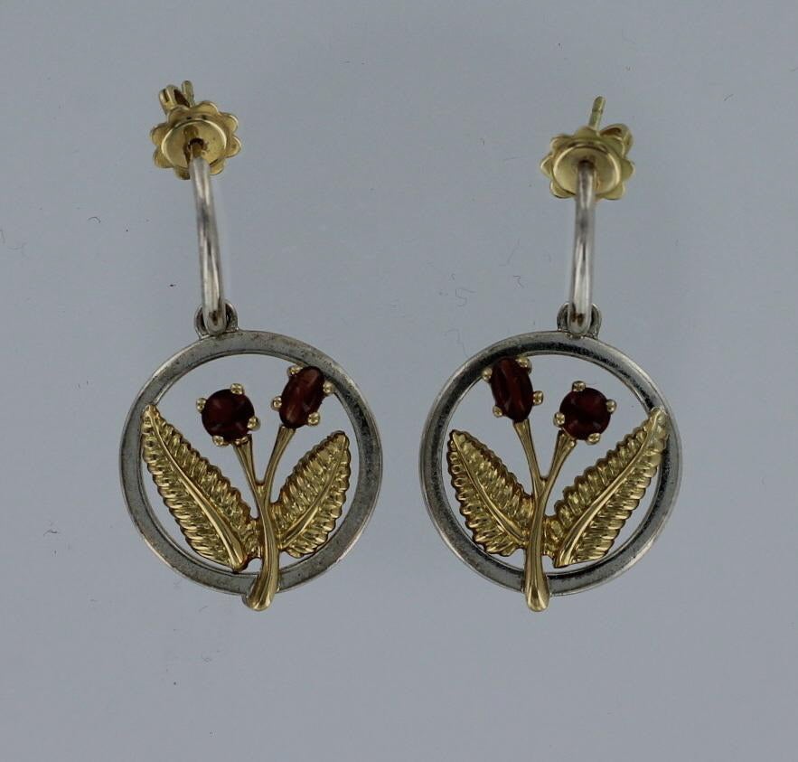 Tiffany & Co. earrings in modern floral motif.  These earrings are 18 karat yellow gold, sterling silver with cabochon garnets.    These earrings are signed and dated 2003.  Each earring measures approximately 3/4-inch in diameter.  The earrings