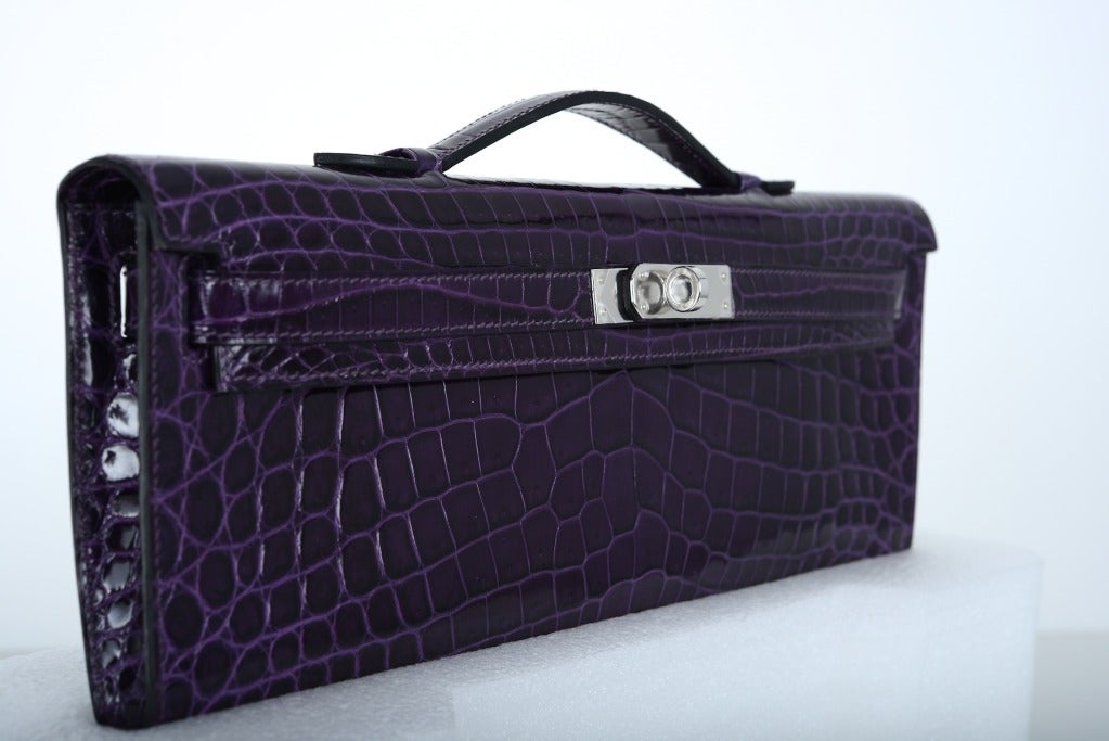 As always, another one of my fab finds, CANT GET THIS.. Hermes KELLY CUT IN THE MOST FABULOUS AMETHYST NILO CROCODILE with PALLADIUM hardware

WE HAVE A MATCHING AMETHYST CDC BOTH PIECES ARE INCREDIBLE TOGETHER. 

MEASURES: 12 1/4 x 5