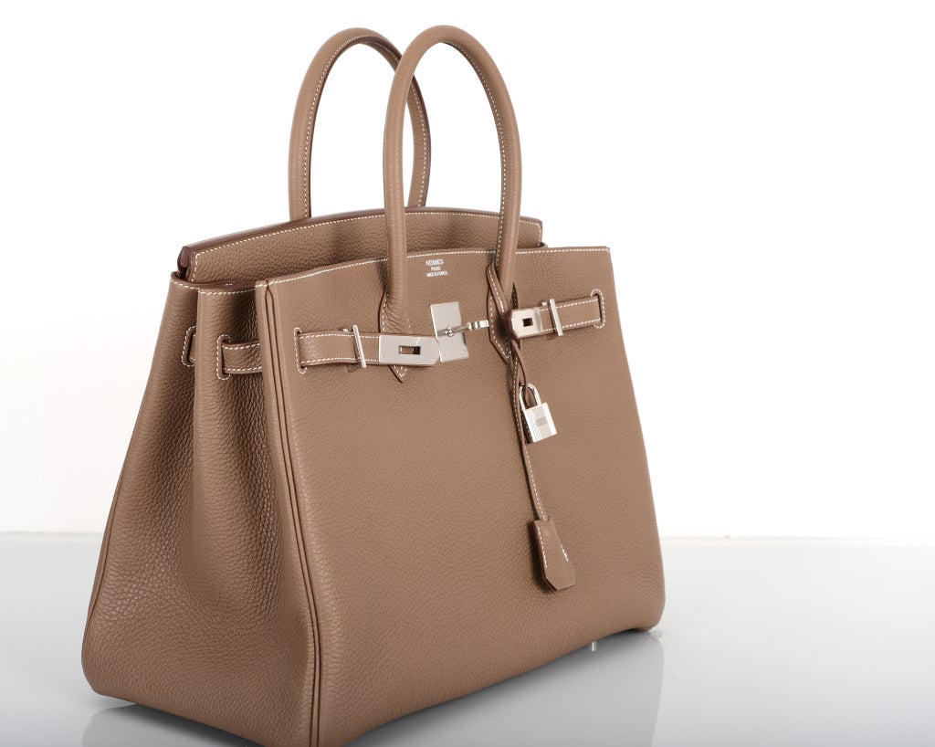 As always, another one of my fab finds! The Hermes 35cm BIRKIN in beautiful CLEMENCE leather in the most beautiful Etoupe color with contrast white stitching.

This bag comes with lock, keys, clochette, a sleeper for the bag, and box.
The bag is