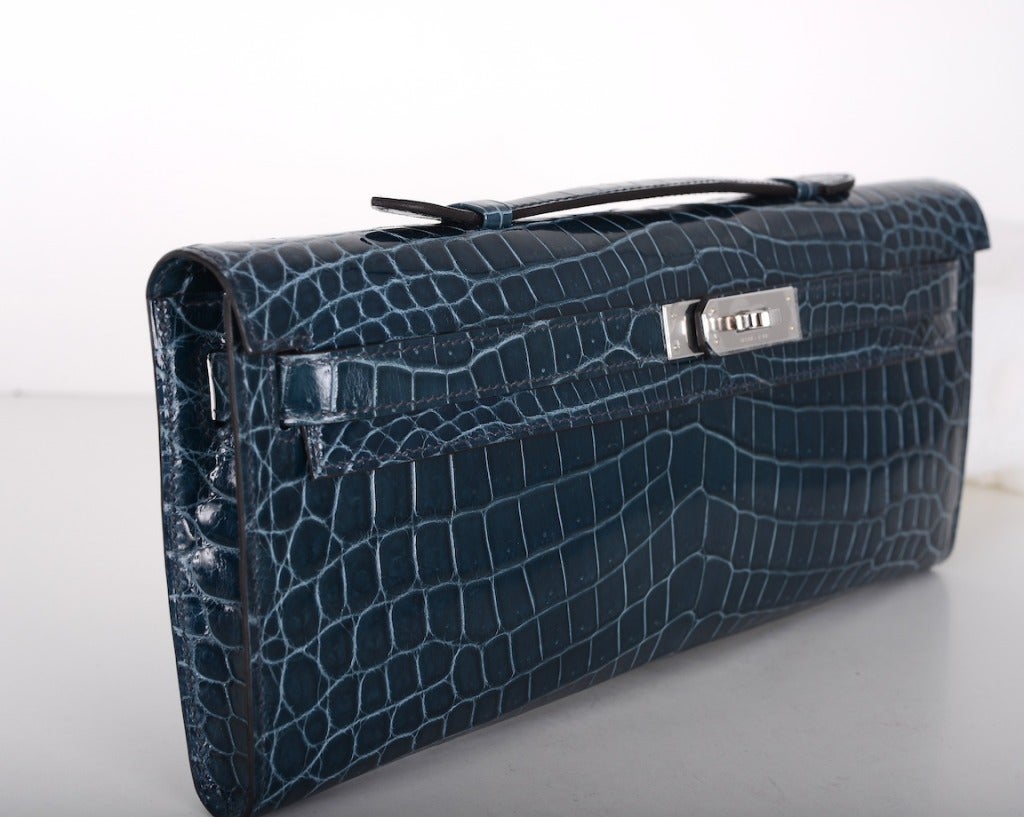 As always, another one of my fab finds! CANT GET THIS! Hermes KELLY CUT IN THE MOST AMAZING BLUE TEMPETE CROCODILE NILO CROCODILE with PALLADIUM hardware.
MEASURES:
12 1/4 x 5