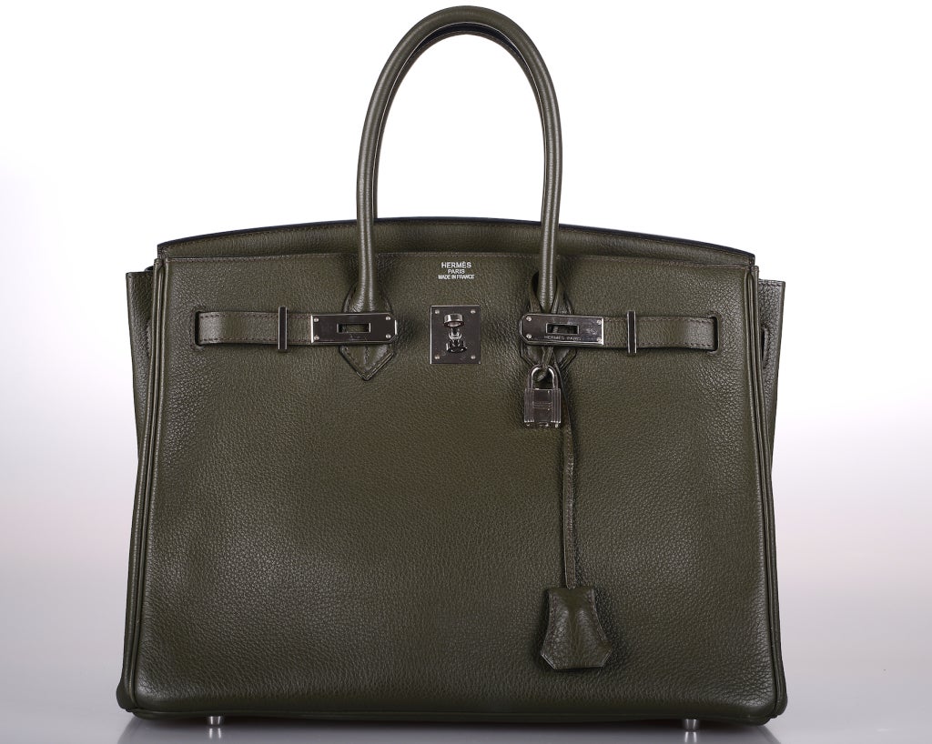 As always, another one of my fab finds! Hermes 35cm Birkin Bag in beautiful super rare VERT BRONZE CLEMENCE LEATHER.

 THE BAG IS ABSOLUTELY A GORGEOUS COLOR, BETWEEN GRAPHITE AND DARK METALLIC GREEN. A CHAMELEON THAT CHANGES COLORS IN DIFFERENT