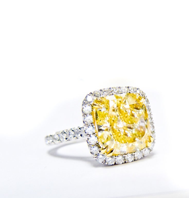 This absolutely vibrant fancy yellow ring, features beautiful 5.02 Carat Fancy Yellow diamond in the center, VS2 in Clarity, surrounded by 1.50 Carats of diamonds. 

The center stone is certified by EGL USA. 

Stunning ring!!!