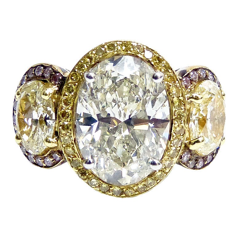 Stunning Three stone ring, amazing workmanship.

The center Oval cut diamond is 4.52 CT. surrounded by fancy yellow diamonds. Along with 2.30 CT. total weight of oval shape diamonds from both sides, surrounded by 0.75 cts of purple pink