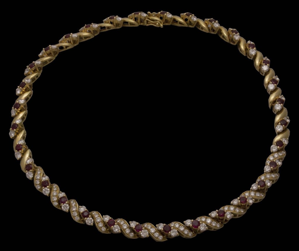 This stunning Chaumet necklace is made of delicate S-shaped rows of 18K gold set with brilliant round diamonds that alternate with sections consisting of a single deep red ruby flanked by one diamond on either side. Numbered 111797.