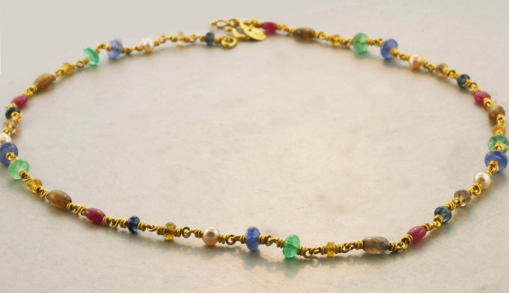 Reinstein Ross necklace with an array of multi-colored sapphires, rubies, pearls and emeralds surround this 22K yellow gold. This necklace is very wearable and matches everything!