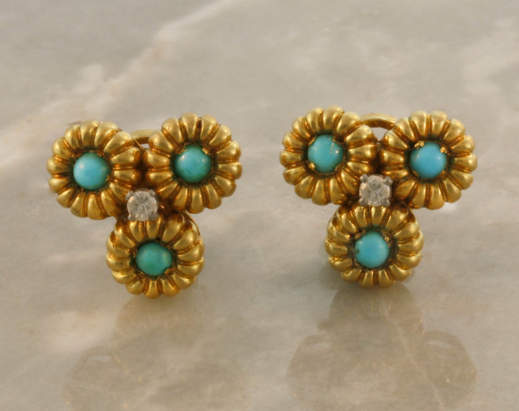 Textured, flower link bracelet and earrings, containing cabochon-cut turquoise mounted in 18k yellow gold. The earrings center contains a beautiful round diamond. Signed Cartier.