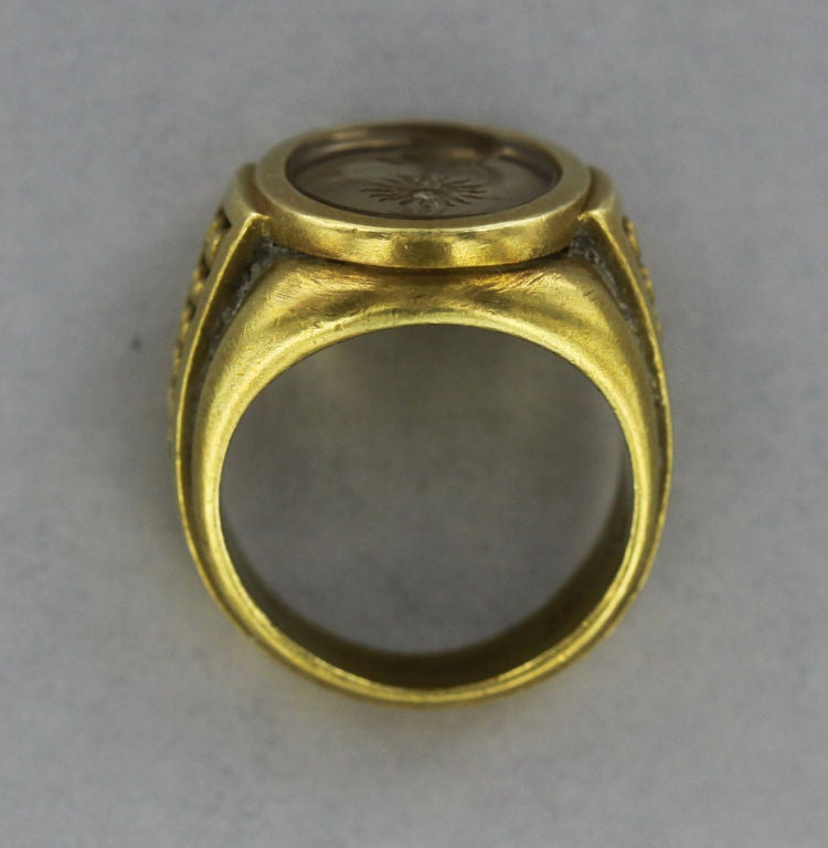 This substantial, 1990’s Kieselstein-Cord 18-karat gold signet ring is set with a citrine with both a sun and moon motif etched into the stone. On either side of the shank are two rows of small gold balls set into a triangular frame.
