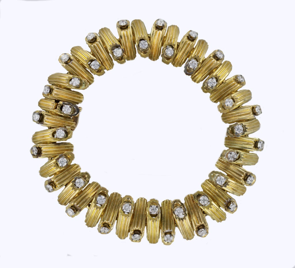 You'll find pure 60's style in this 18K yellow gold Van Cleef & Arpels telescoping snake bracelet. Each incised segment showcases  a sparkling round-cut diamond set into 18K white gold.
