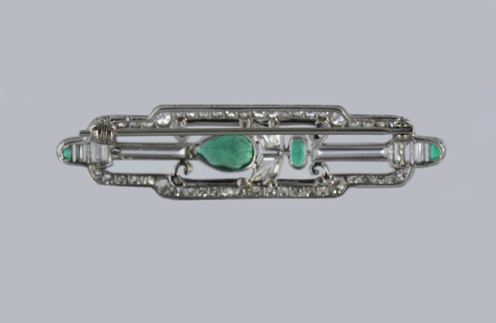 This exquisite and delicate Cartier brooch epitomizes classic Art Deco chic. Glittering diamonds in varying shapes-kite, round cut and long baguettes-are set into platinum along with rich green oval and half-moon emeralds, and black enamel.