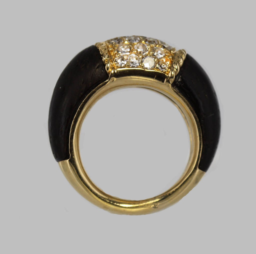 The Van Cleef & Arpels tradition of combining unusual materials is seen in the largest version of this sixties-chic ring from their Phillipine collection. A dome with rows of round-cut diamonds is set into a shank of rich gold contrasting with dark
