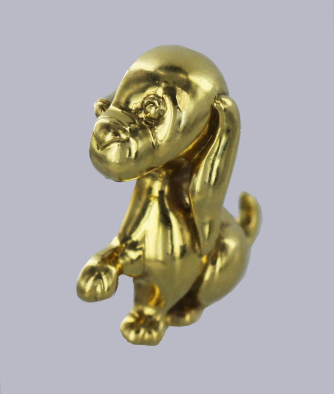 This charming 18K gold pin created by Mauboussin, Paris in the 1970's is of a seated dog with one outstretched paw and a wagging tail.