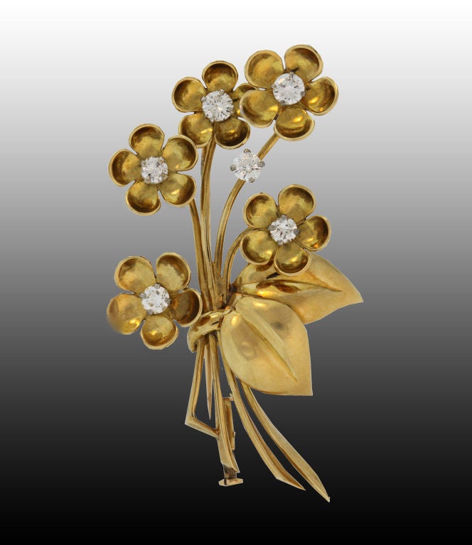 This 1940's Van Cleef & Arpels 18K yellow gold and diamond five-flower brooch features six fine diamonds set into the flower centers with an additional gem gracing one of the delicately arched stems. Numbered 56961.