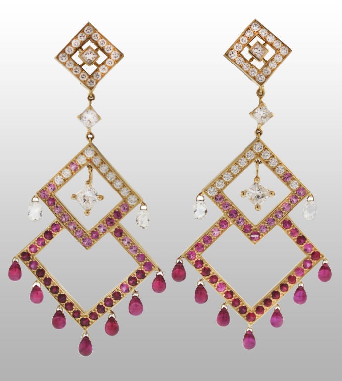 These stunning and dramatic contemporary Boucheron chandelier earrings are composed of three graduated 18K gold diamond-shaped frames, set with a combination of diamonds, rubies and pink sapphires. Individual diamond briolettes and ruby drops dangle